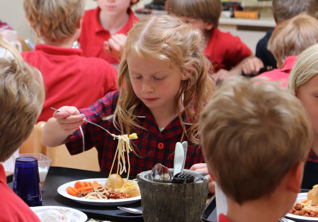 A young student eating a vegetarian meal.